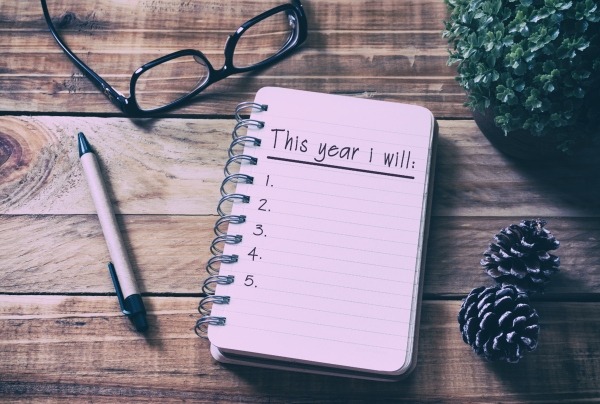 aerial view of a note pad to-do list, a pair of glasses and a pen