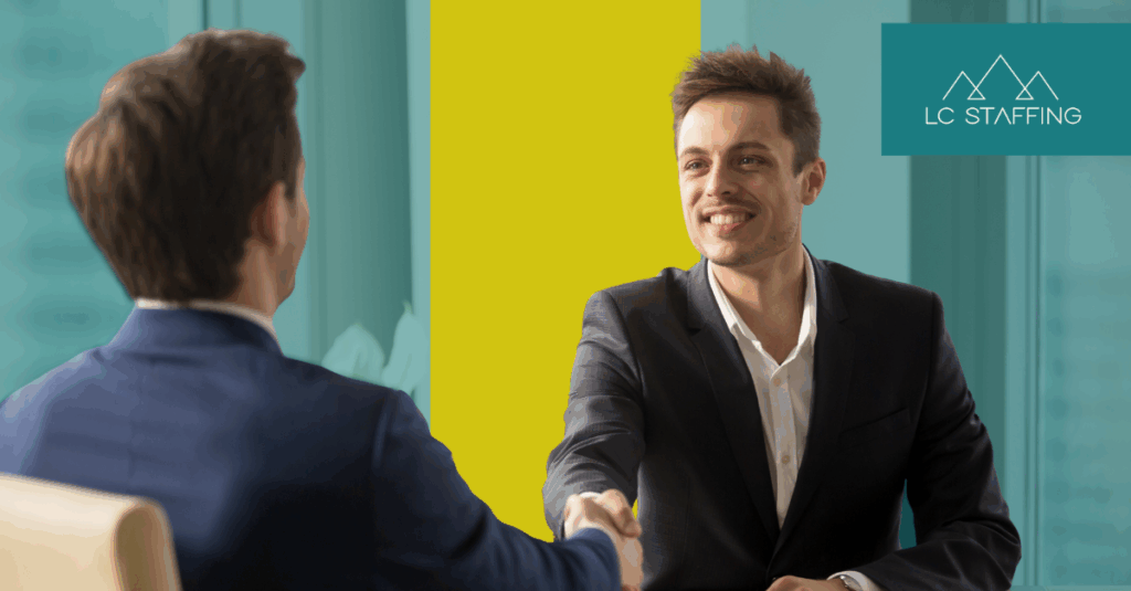 Two professionals shaking hands across a table, representing a successful Montana hiring outcome in a competitive labor market.