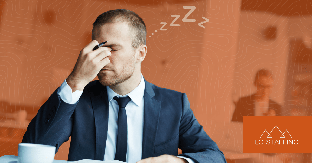 Exhausted office worker at his desk illustrating the need for contingent labor to reduce employee burnout.