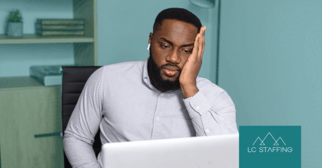 A frustrated hiring manager at his laptop dealing with hiring bottlenecks that slow down the recruitment process.